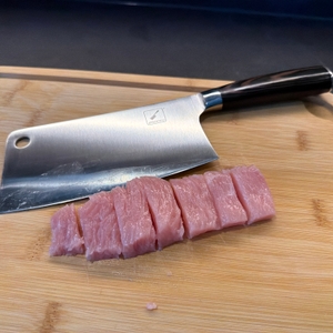 Das imarku-Küchenmesser liegt neben zerschnittenen Stücken Fleisch