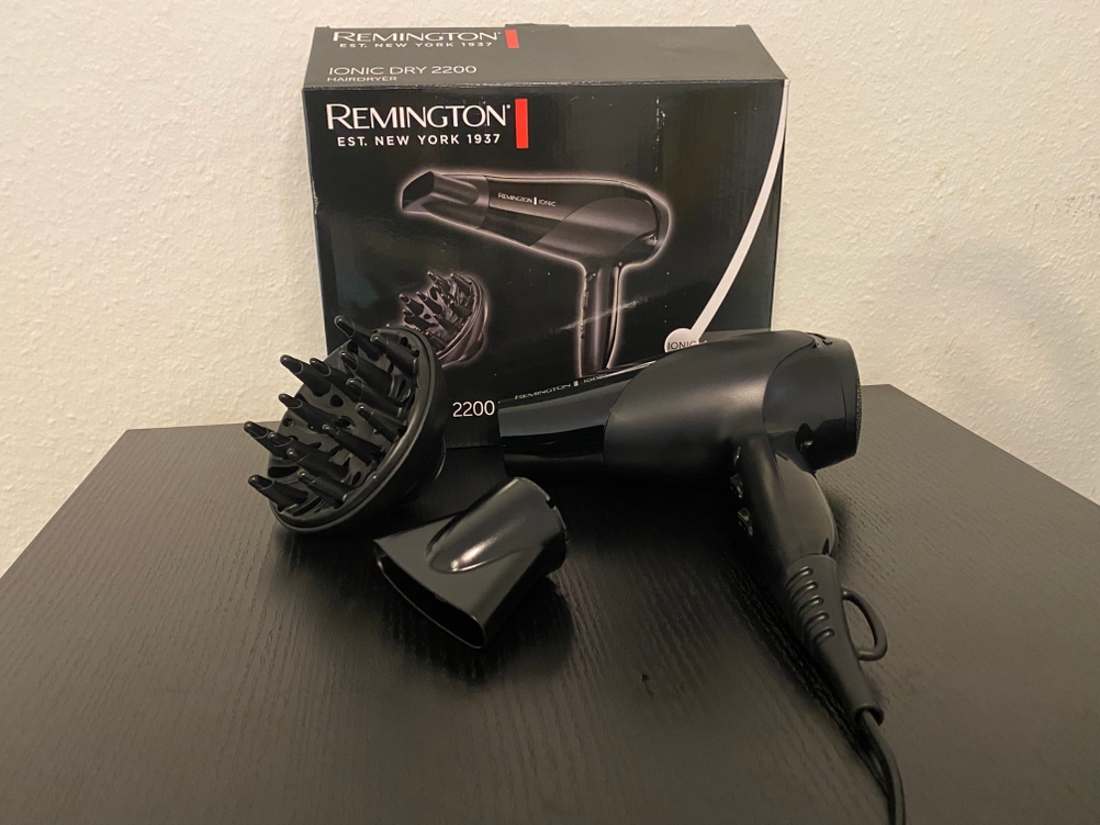 Hier ist die Originalverpackung und der Haartrockner samt Zubehör zu sehen.