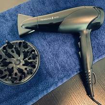 Auf einem blauen Handtuch liegt der Ionen-Haartrockner Remington Ionic D3198