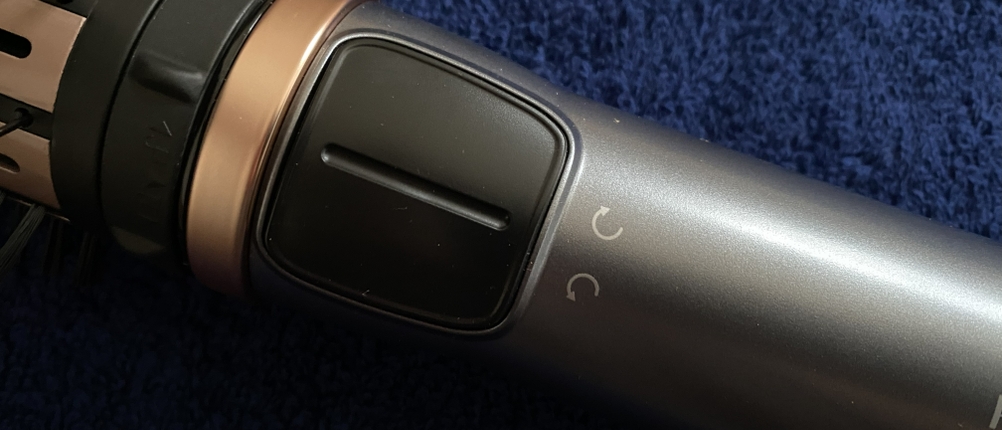 Großaufnahme des Griffs der Remington AS8811 Warmluftbürste mit Rotationstasten.