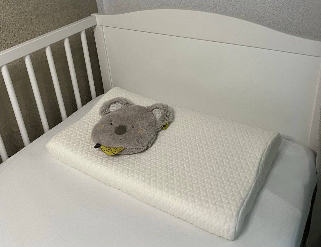 Kinderkissen auf Bett mit Plüschkissen