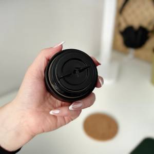 Eine Hand hält den Deckel mit der Trinköffnung des 720°Dgree-Thermobechers.