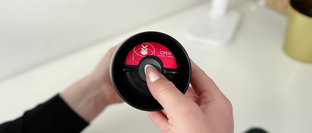 Eine Person mit langen Fingernägeln betätigt die Trinköffnung des Thermobechers Emsa Waves Grande.