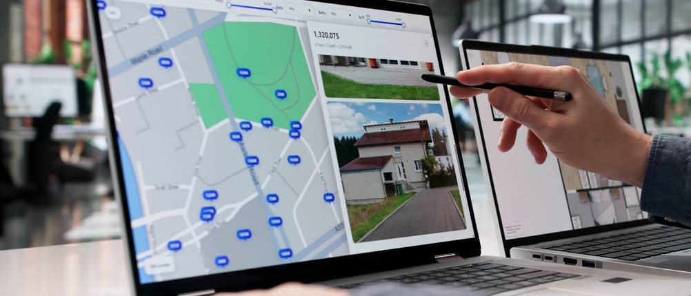 Eine Person prüft am PC über ein Immobilienportal die Preise.
