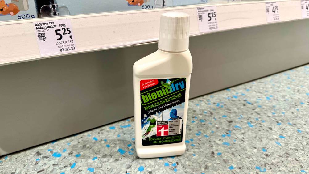 Vor einem Regal auf dem Boden steht das Imprägnier-Waschmittel im Test.