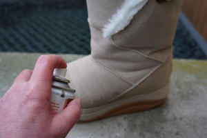 Ein Winterschuh wird mit Imprägnierspray besprüht