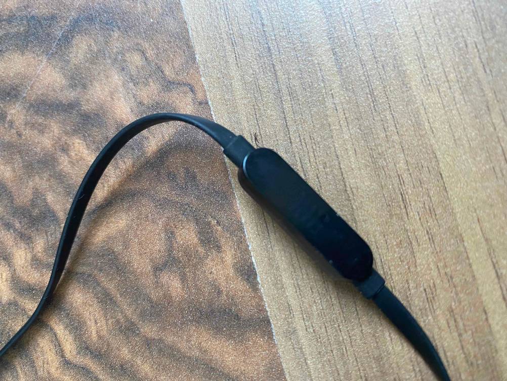 In-Ear-Kopfhörer-mit-Kabel im Test: Auf einem Holzboden befinden sich In-Ear-Kopfhörer-mit-Kabel und integriertem Mikrofon.