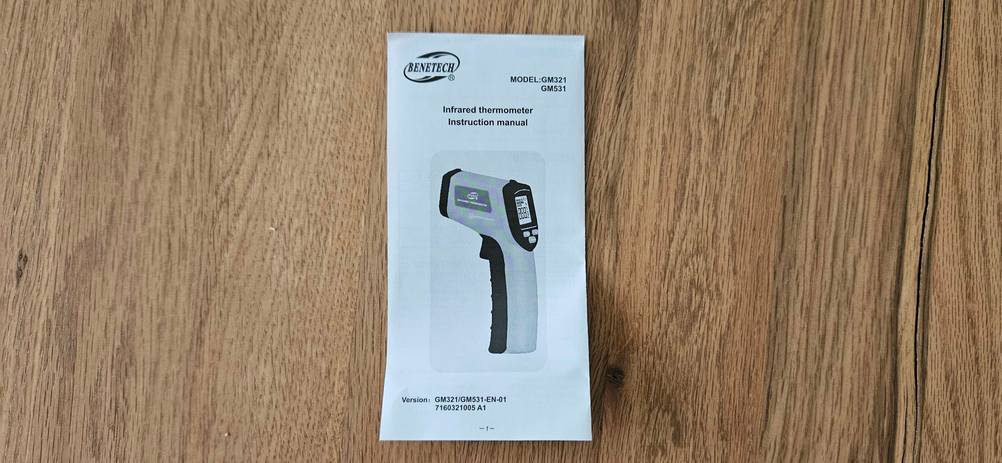 Infrarot-Thermometer getestet: Die Bedienungsanleitung des Geräten von oben auf einer Holzfläche.
