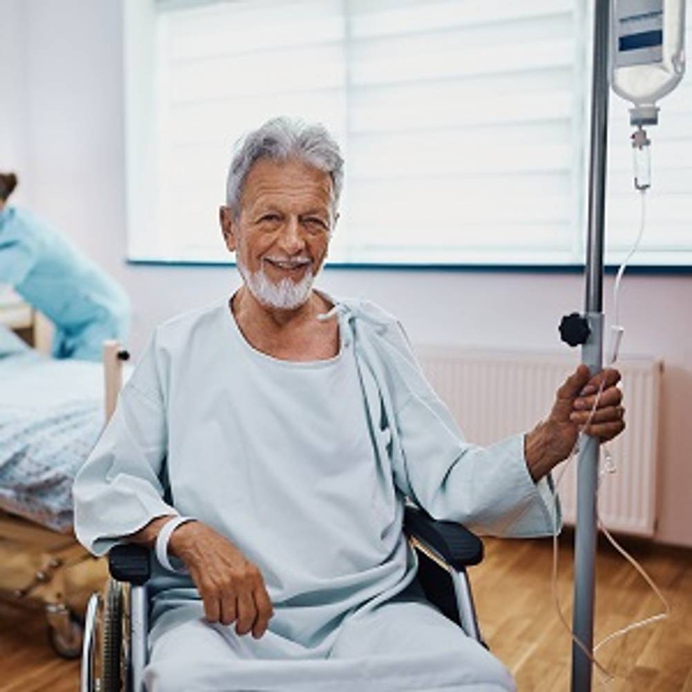 Infusionsständer getestet: Mann im Rollstuhl neben einem Infusionsständer.