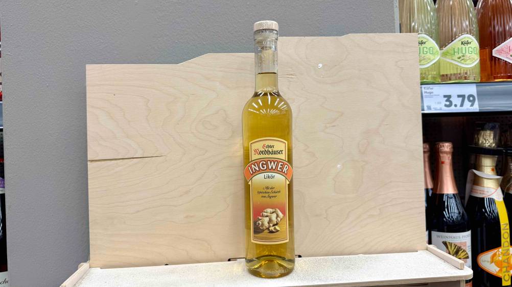 Eine Flasche des getesteten Ingwerlikörs vor einem Holzbrett.