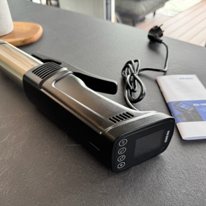 Der Inkbird ISV-100W liegt neben seiner Anleitung auf einer Arbeitsplatte