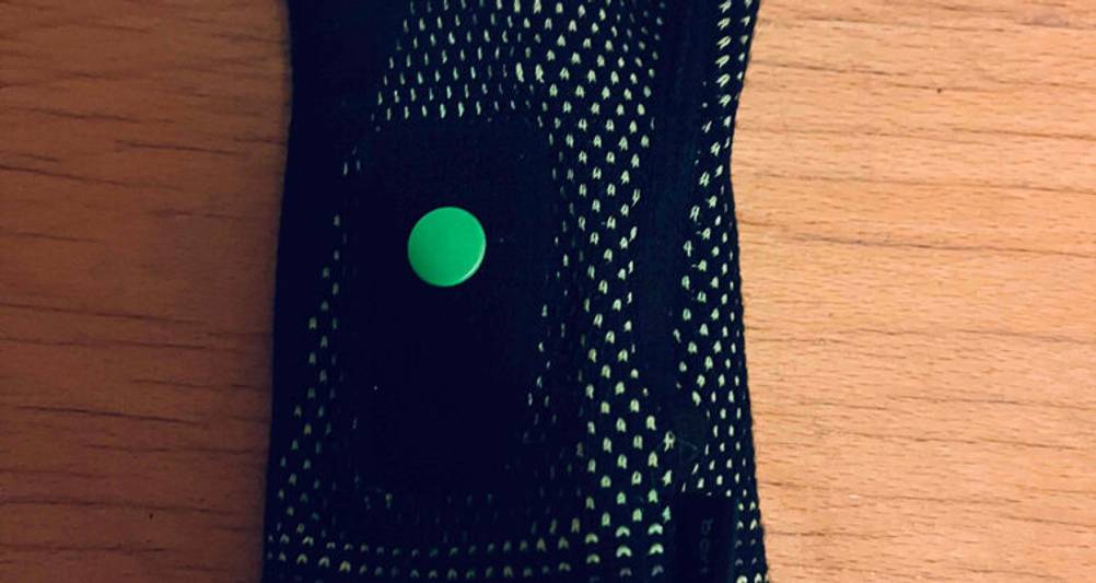 Nahaufnahme vom grünen Druckknopf eines schwarzen getesteten Inliner-Protektors.