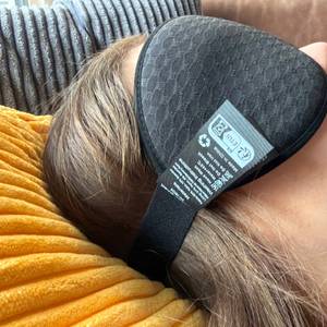 Eine Person mit der Innelo-Schlafmaske liegt auf einem Kissen.