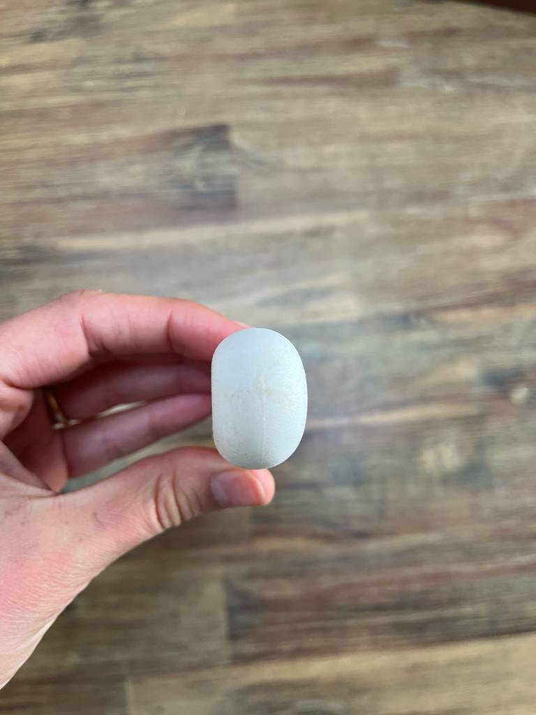 Eine Hand zeigt das äußere Ende vom weißen Handgriff eines Austernmessers.