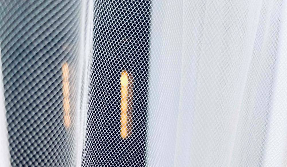 Insektenschutz-Vorhang im Test: Nahaufnahme eines weißen Vorhangs im Gittermaschen-Design.