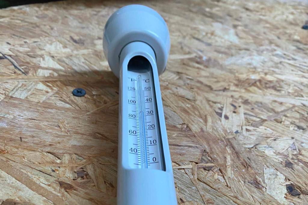 Im Test: Poolthermometer liegt auf Sperrholz.
