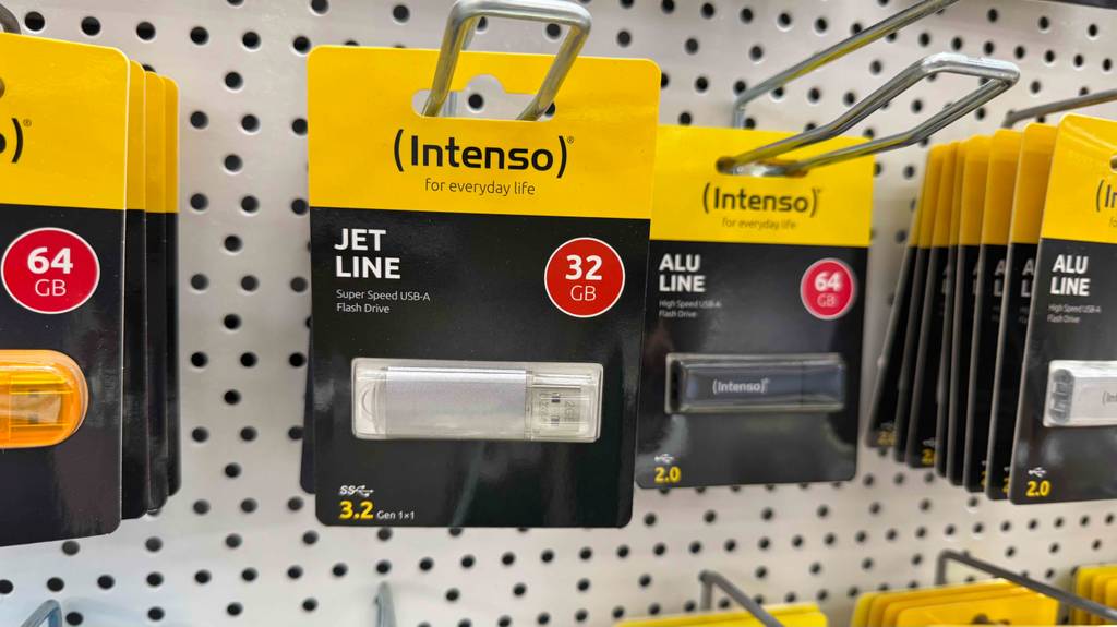 Mehrere getestete USB-3.2-Sticks in unterschiedlichen Farben hängen an einem Verkaufsstand.