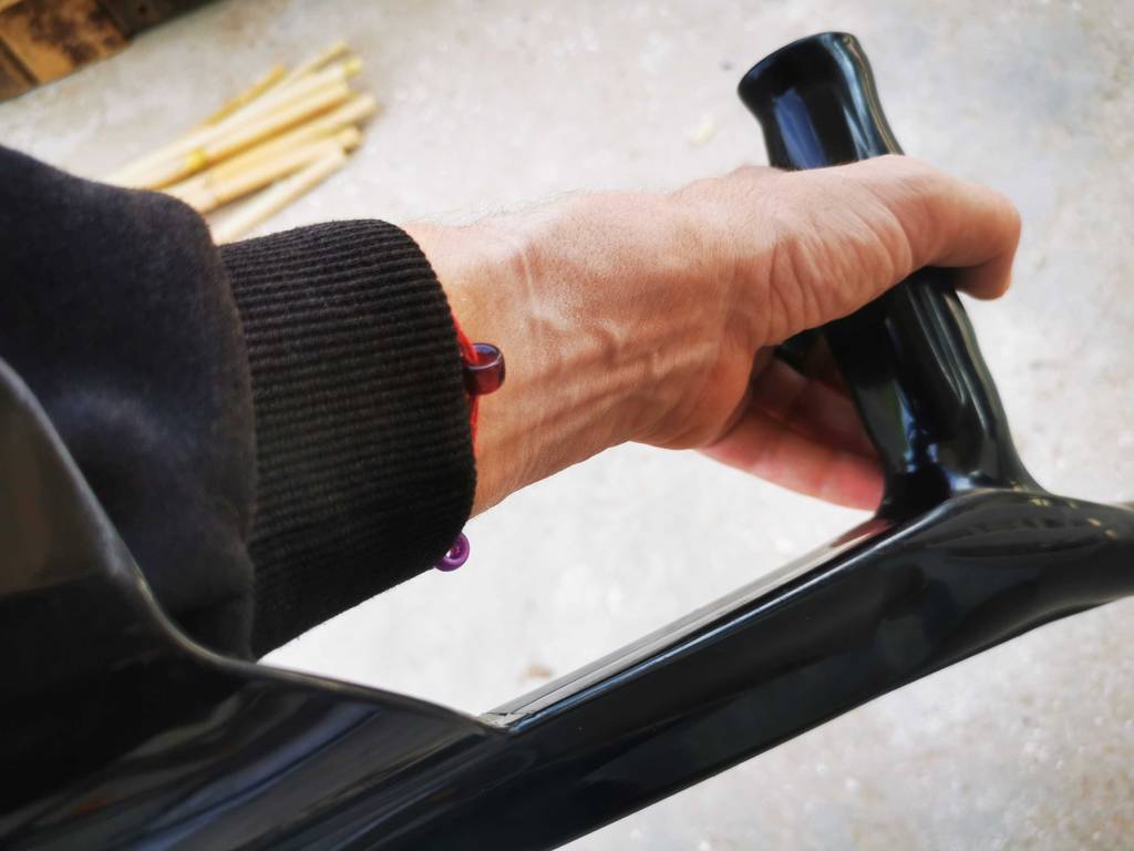 EineHand greift den ergonomischen, schwarzen Griff, der sich an der getesteten Krücke befindet.