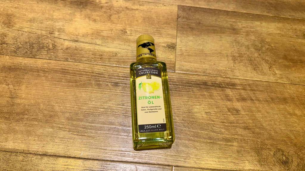 Im Test: Zitronenöl in einer 250-ml-Flasche liegt auf einer Holzfläche.