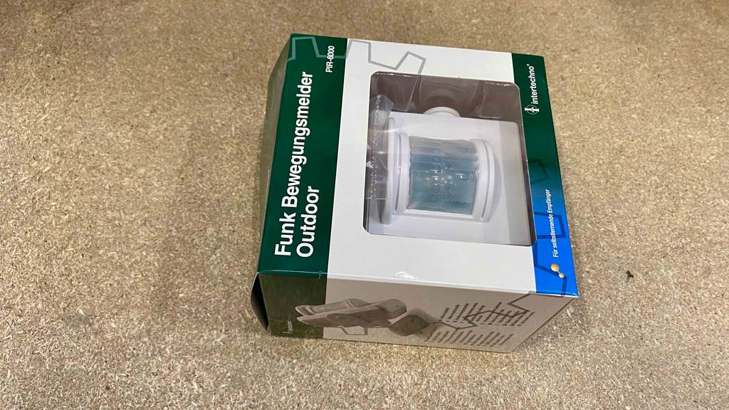 Bewegungsmelder im Test: eine weiße Verpackung mit Sichtfenster zeigt einen Funk-Outdoor-Bewegungsmelder von Intertechno.
