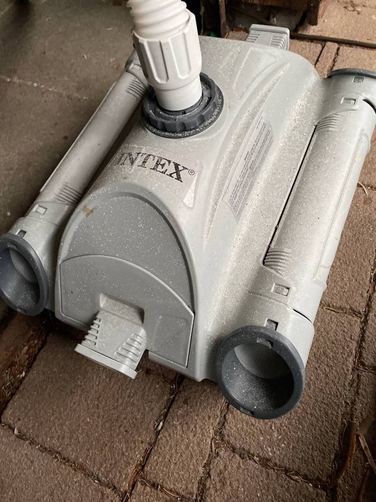 Poolroboter im Test: Nahaufnahme eines hellgrauen, durch Sand verschmutzten Modells von Intex.