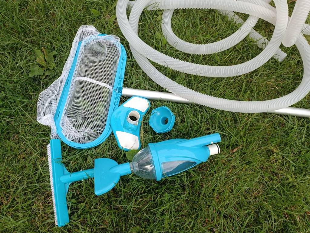 Ein getestetes Poolsauger-Reinigungsset in Türkis liegt auf einem Rasen.
