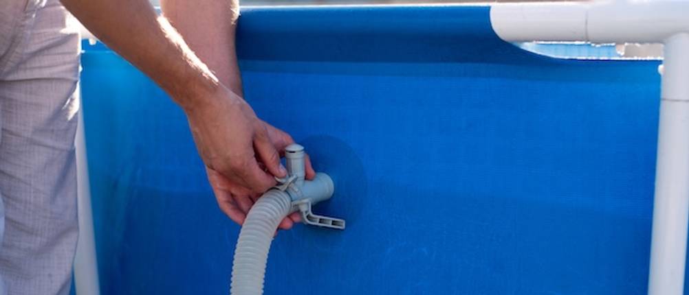 Intex-Filterpumpe-Test: Ein Schlauch wird an einem Aufstellpool befestigt.