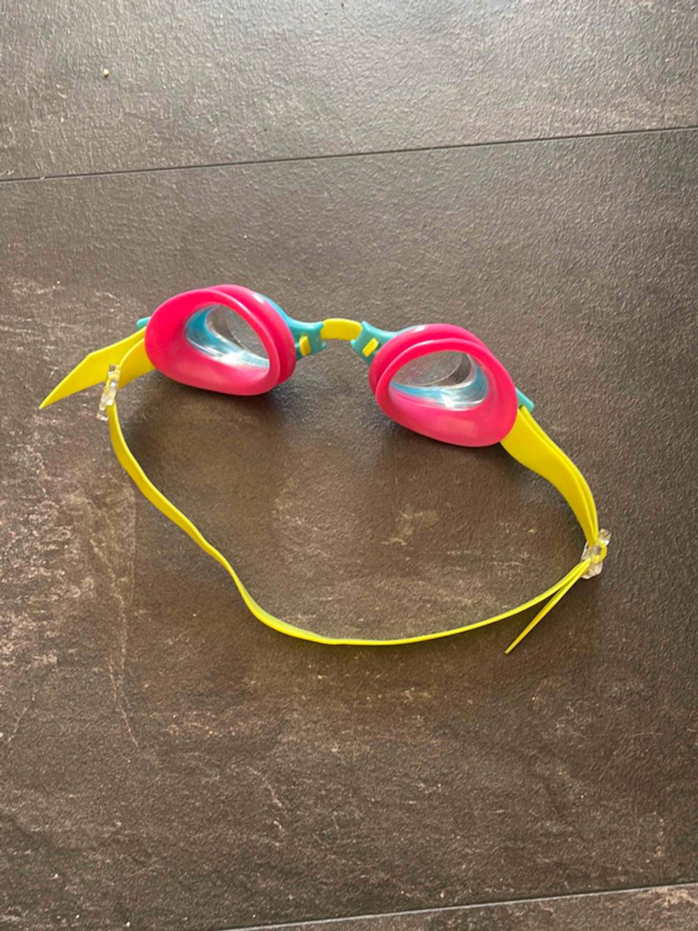 Im Test: Rückseite einer Schwimmbrille für Kinder auf einer dunklen Fläche.