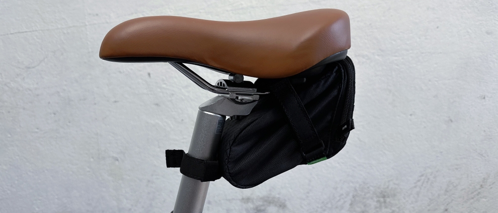 Der Invoxia GPS Tracker steckt in einer kleinen schwarzen Satteltasche unter dem Fahrradsattel. Die Tasche ist mit Riemen befestigt.