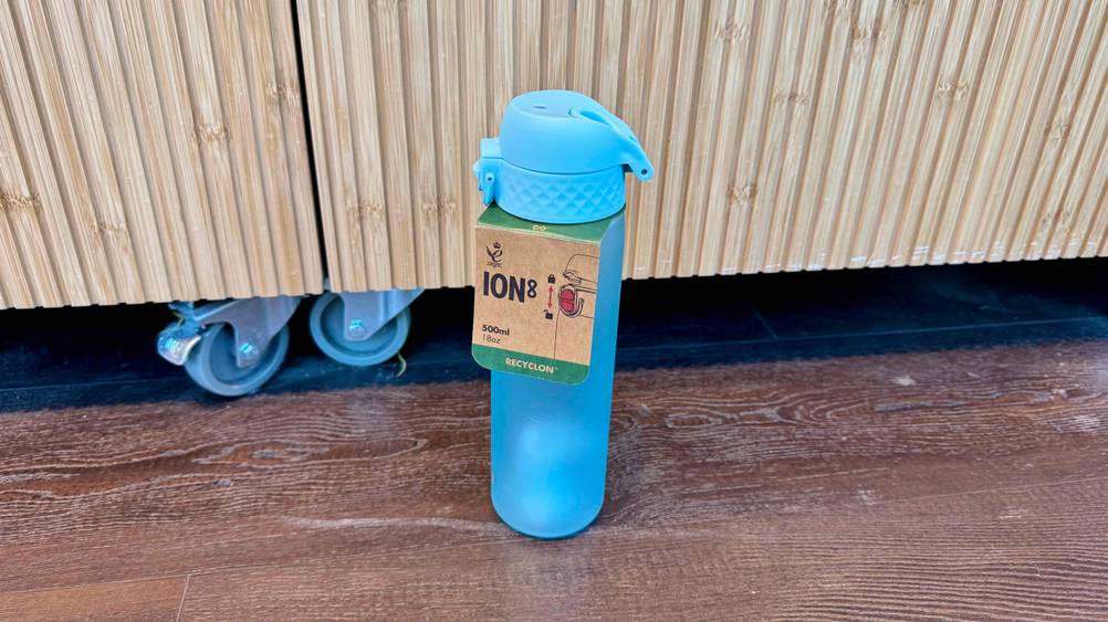 Eine getestete ion8-Trinkflasche von schräg oben auf einem Boden stehend.