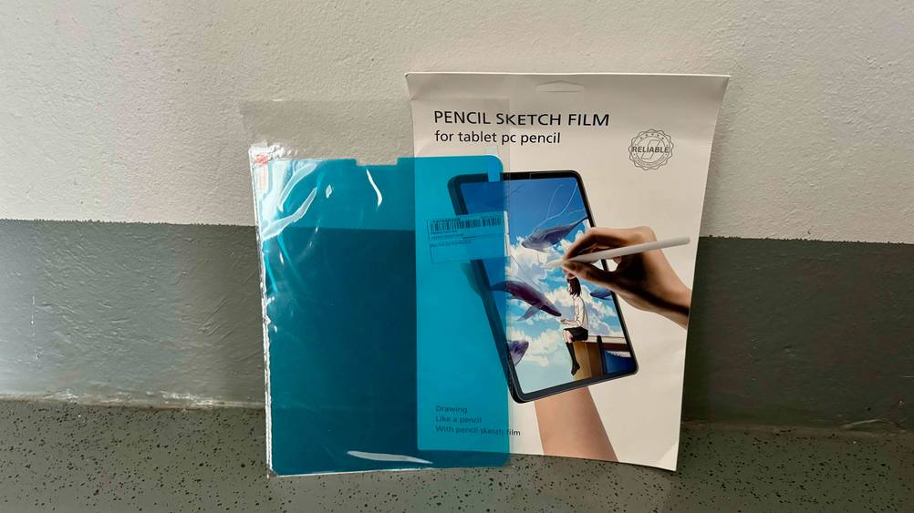 Ein ausgepacktes iPad-Pro-12.9-Panzerglas im Test steht neben seiner Originalverpackung an einer Wand.