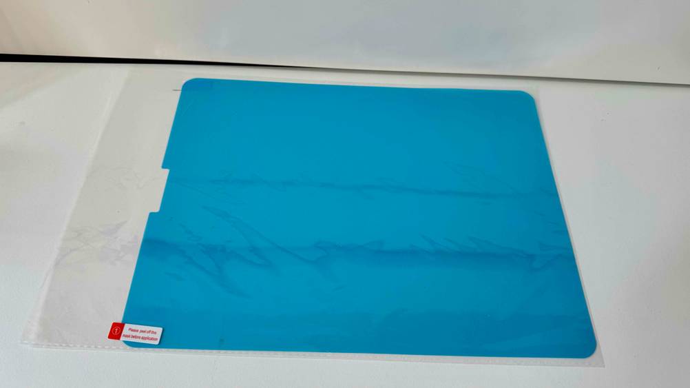 Ein verpacktes iPad-Pro-12.9-Panzerglas im Test auf einer hellen Fläche.