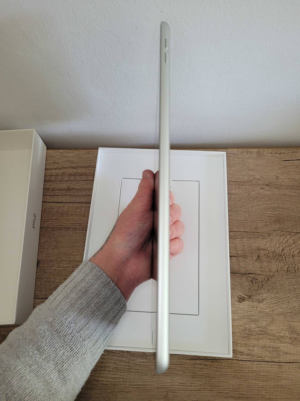 Ein Mann hält ein getestetes Apple iPad in der Hand und zeigt es von der Seite.