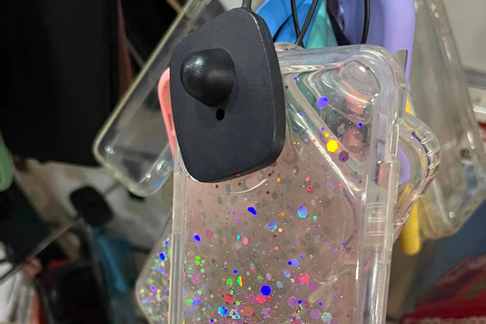 iPhone-12-Mini-Hülle-Test: Eine Glitzerhülle wird am Verkaufsstand in die Hand genommen.