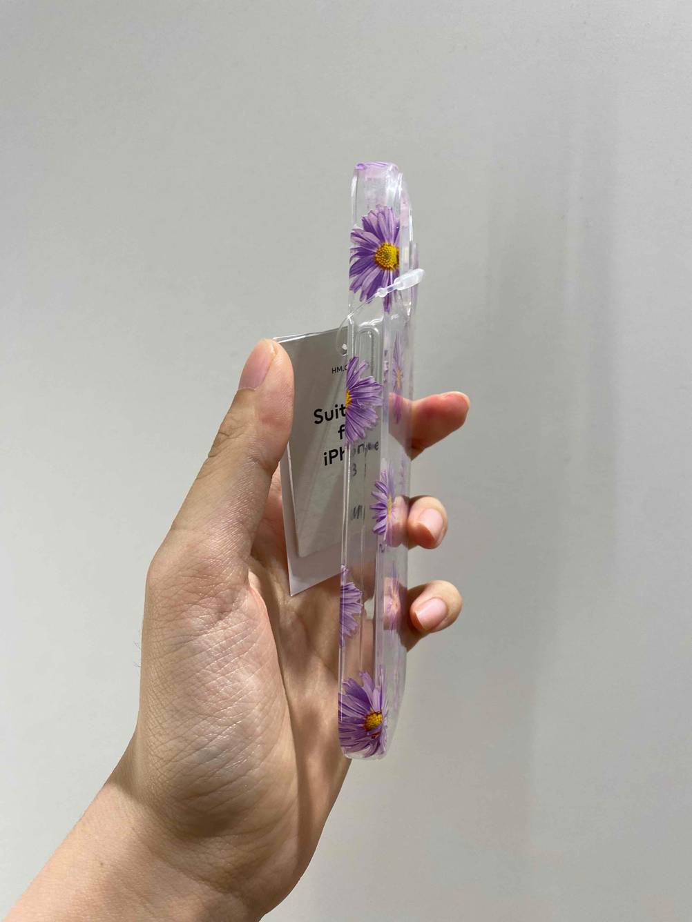 iPhone-13-Hülle im Test: Eine Hand hält eine Hülle seitlich vor eine helle Wand.