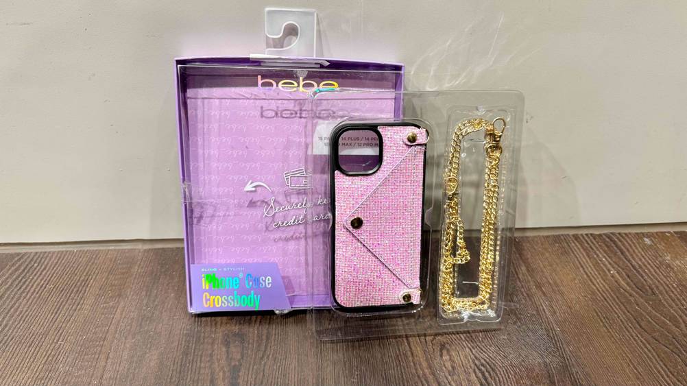 Eine getestete iPhone-14-Plus-Hülle mit Kette und Verpackung vor einer hellen Wand.