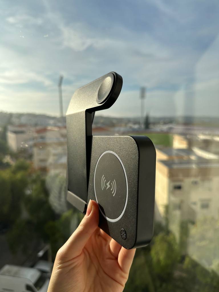 iPhone-Ladestation im Test: Eine Hand hält eine zusammengeklappte iPhone-Ladestation vor ein Fenster.