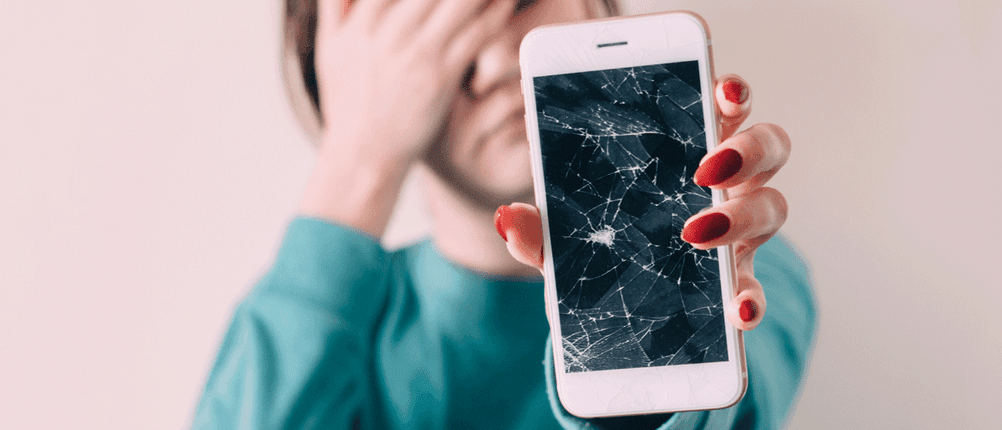 Traurige Frau mit beschädigtem Handy-Display
