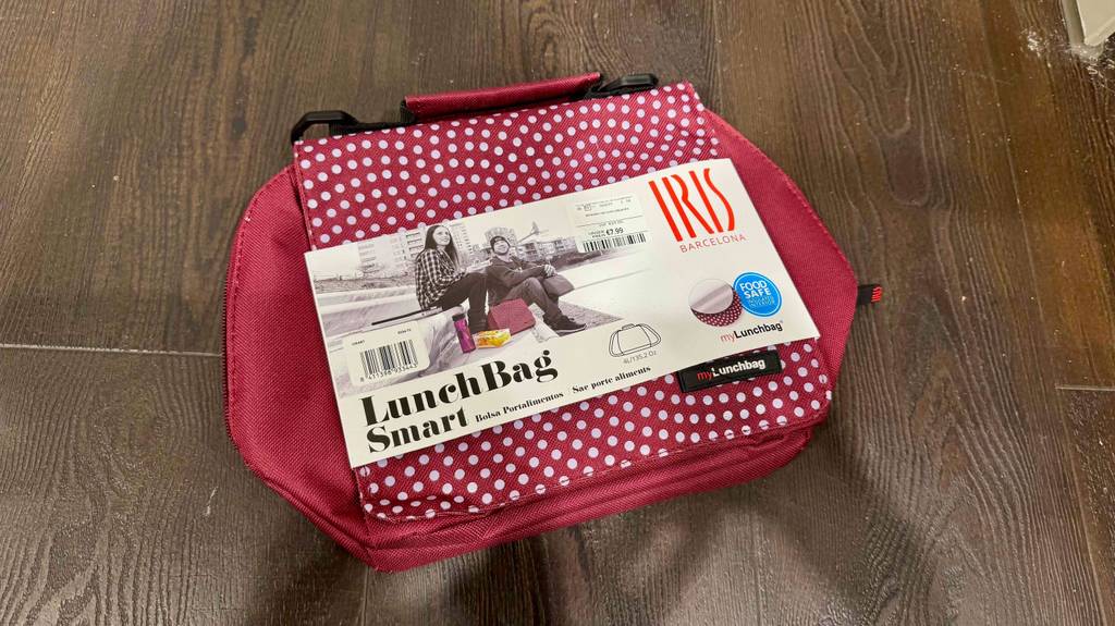 Eine Lunchbag liegt mit Kartonblister zum testen auf einer Holzfläche.