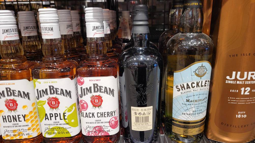 Getestet: Eine Flasche Irischer Whiskey steht mit der Rückseite nach vorne neben anderen Flaschen im Regal.