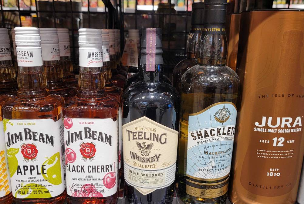 Eine Flasche getesteter Irischer Whiskey steht neben anderen Produkten im Regal.