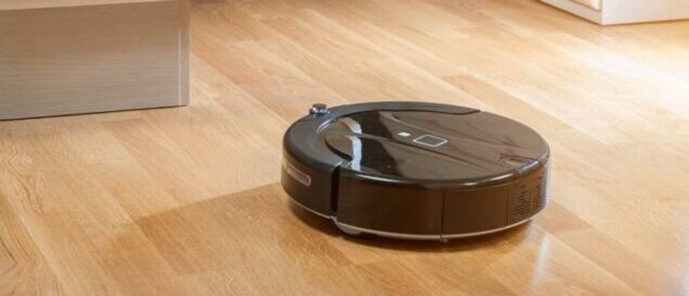 iRobot-Staubsauger-Roboter im Test: Ein schwarzer iRobot-Staubsauger-Roboter auf einem Parkettboden.