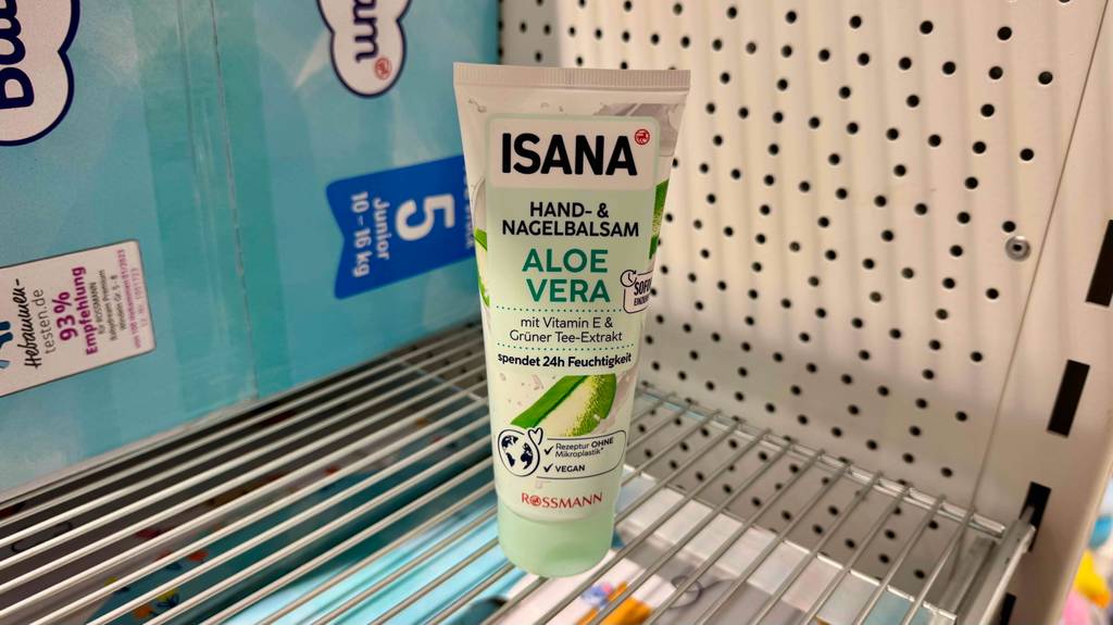 Eine Tube Aloe-Vera-Handcreme steht zum testen in einem Regal vor einer Packung Windeln.