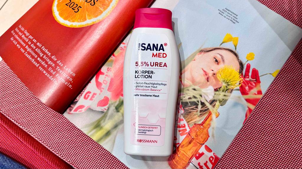 Eine Flasche Bodylotion mit Urea liegt zum testen auf einer Zeitschrift.