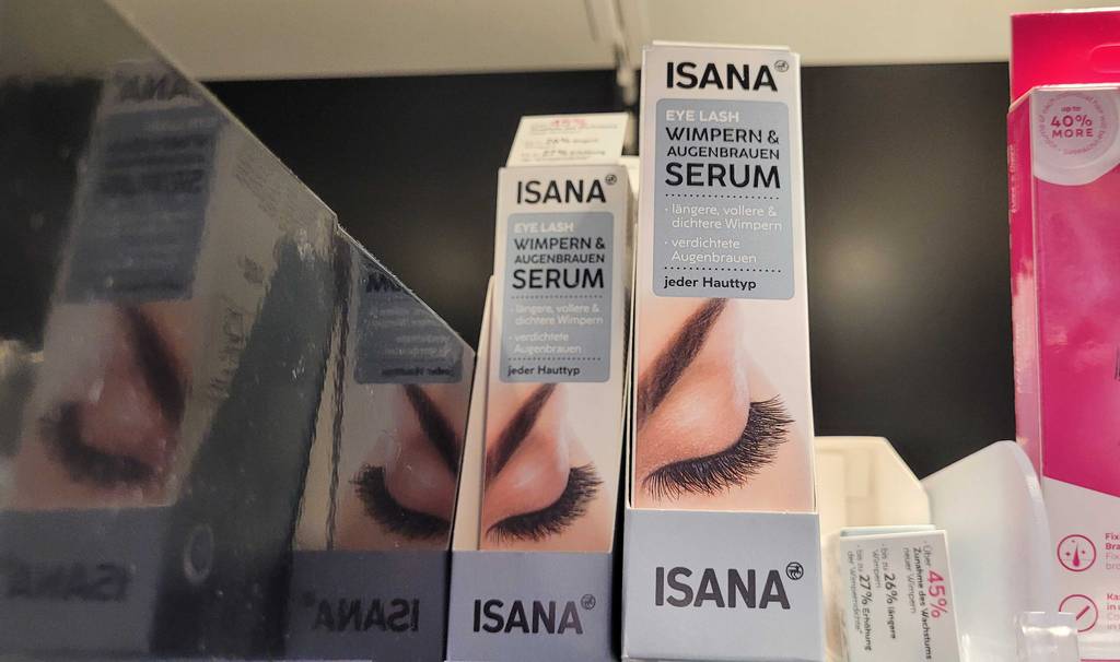 Im Test: Mehrere Packungen Wimpernserum stehen neben und hintereinander in einem Regal.