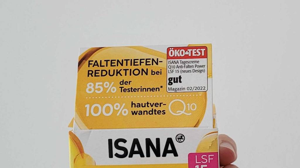 Hand hält eine Isana Q10 Anti-Falten Tagescreme mit LSF15