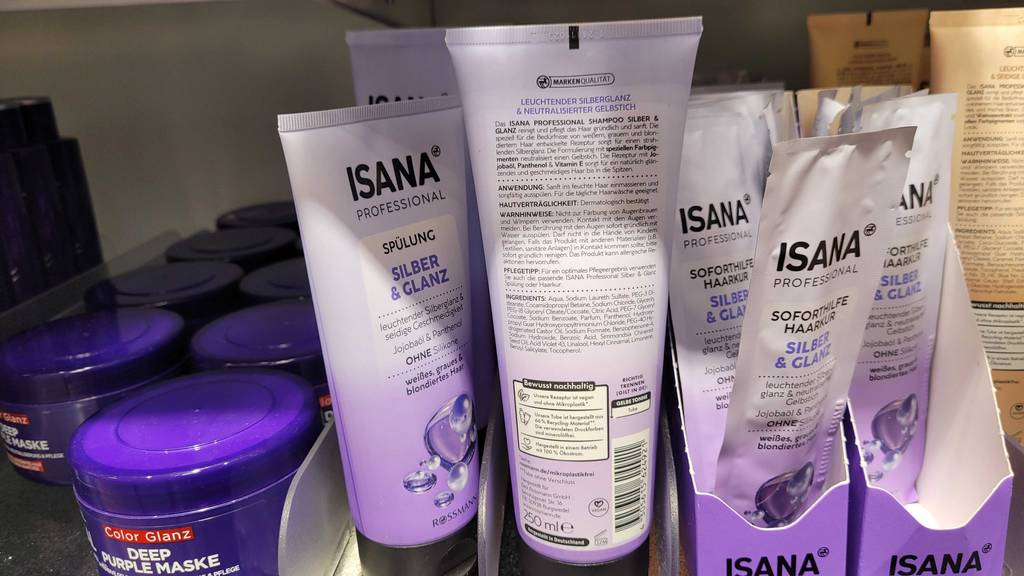 Inmitten unterschiedlicher Haarpflegeprodukte von Isana im weiß-violetten Design befindet sich ein Silbershampoo im Test.