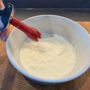 Noch flüssige Sahne in einer Schale, davor der Aufsatz des iSi 1603