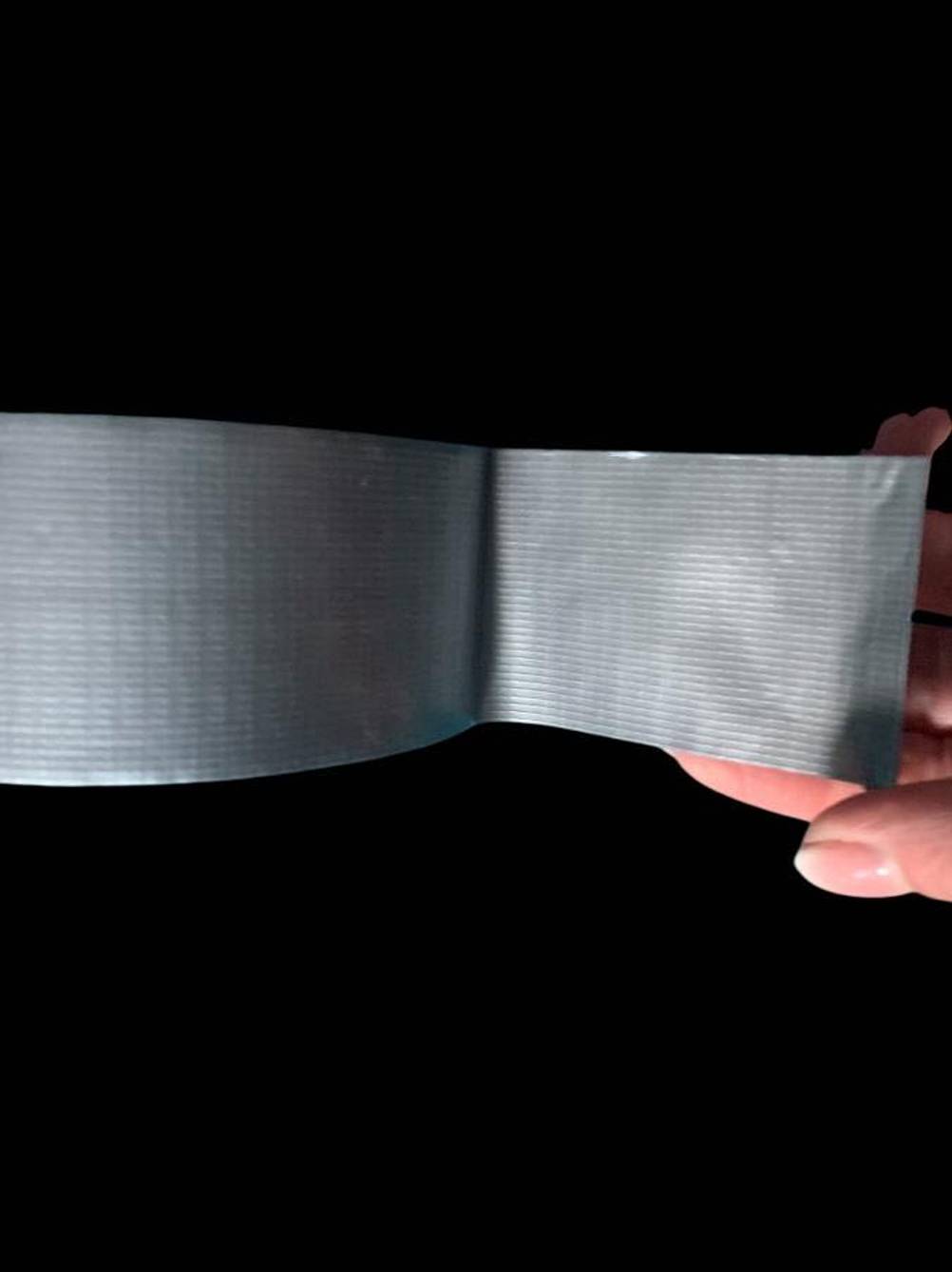 Das Isolierband im Test wird von einer Hand von der Rolle gezogen.