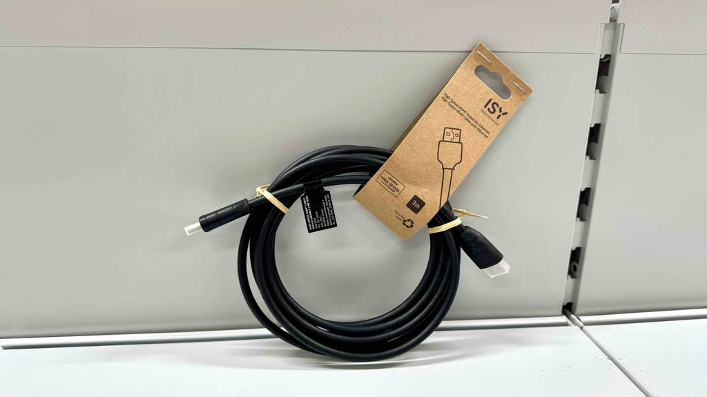 HDMI-Kabel im Test: Ein aufgerolltes, schwarzes 3-m-Kabel lehnt an einer weißen Wand.
